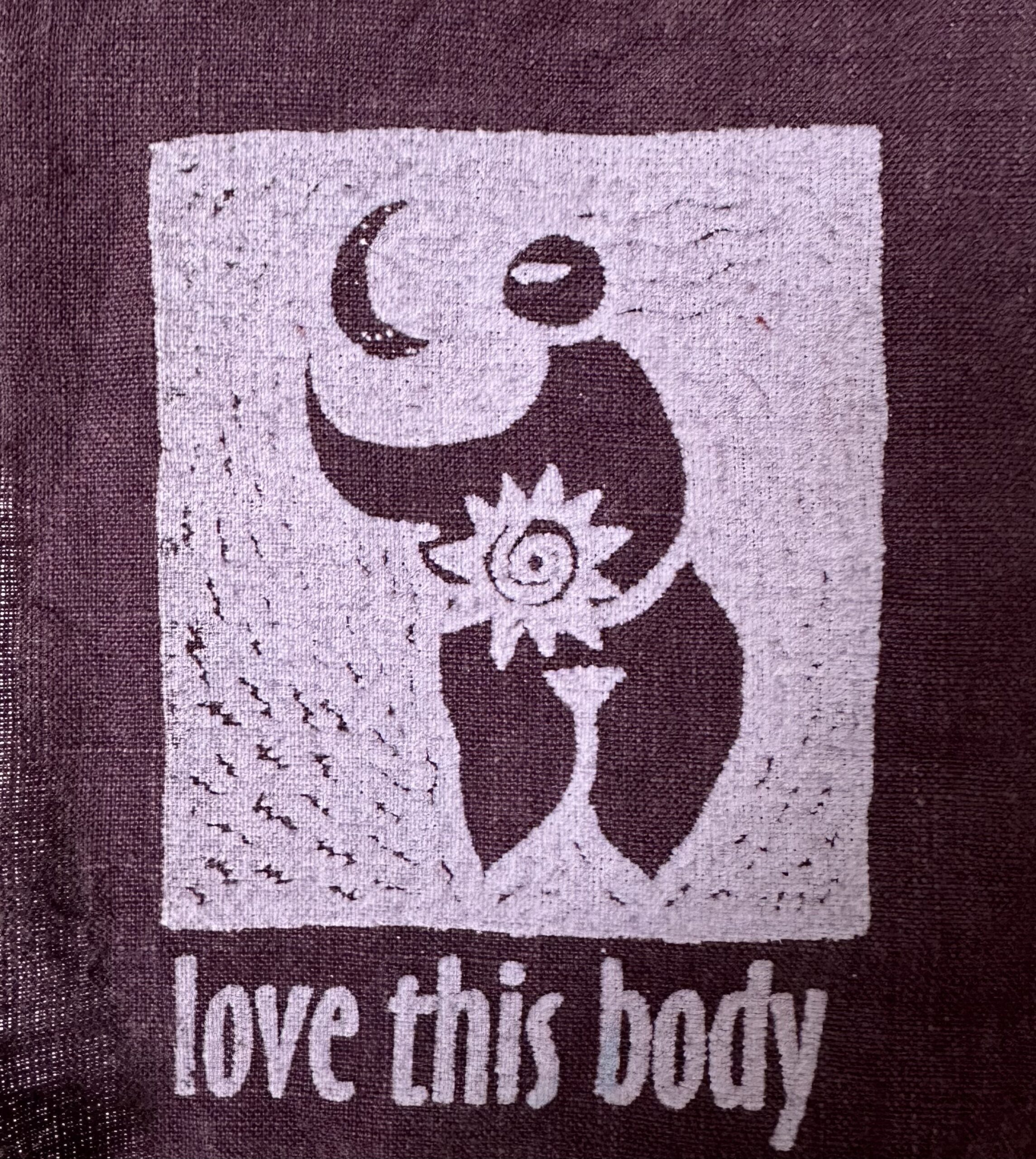 needlepoint art with rounded human figure with the words "love this body"